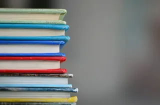 Ein Stapel Bücher mit unterschiedlich farbigen Einbänden.